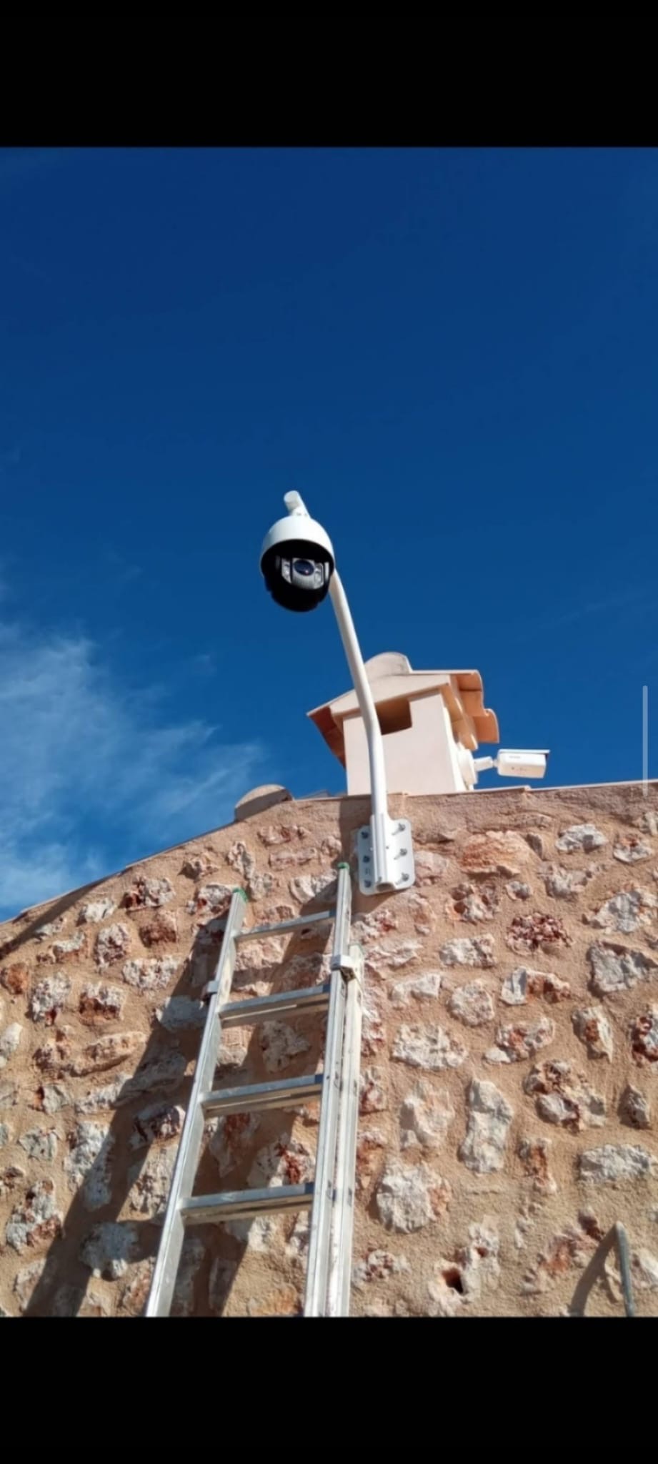 Cámara instalada sobre un soporte en una fachada de piedra